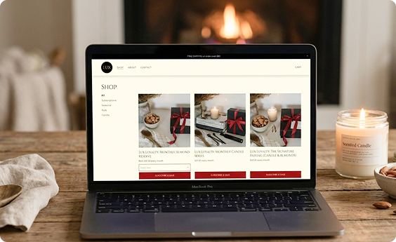 A computer with LUX storefront on a table in front of a fireplace.